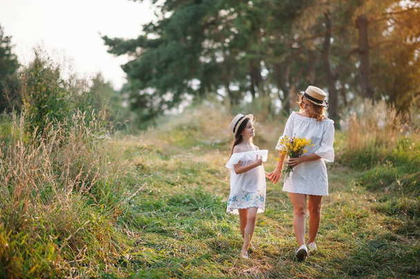 Mother and daughter having fun in the park. Happiness and harmony in family life. Beauty nature scene with family outdoor lifestyle. - Foto, Imagen