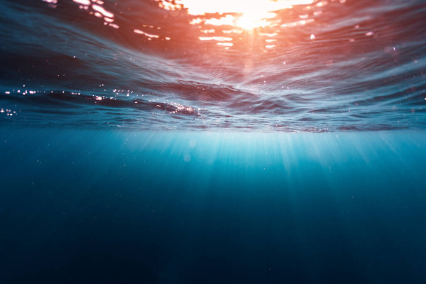 Подводная съемка поверхности моря с солнечными лучами и волнами
 - Фото, изображение