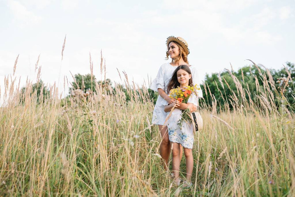 Mother and daughter having fun in the park. Happiness and harmony in family life. Beauty nature scene with family outdoor lifestyle. - Foto, Imagem