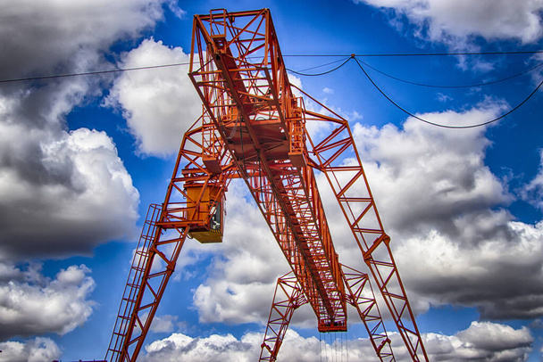The work of a gantry crane. Industrial site. Cargo loading against a cloudy sky. HDR photo. - Photo, Image