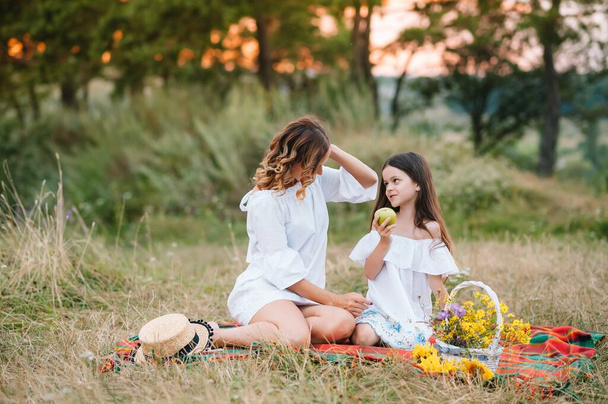 Stylish mother and handsome daughter having fun on the nature. Happy family concept. Beauty nature scene with family outdoor lifestyle. family resting together. Happiness in family life. Mothers day - Zdjęcie, obraz