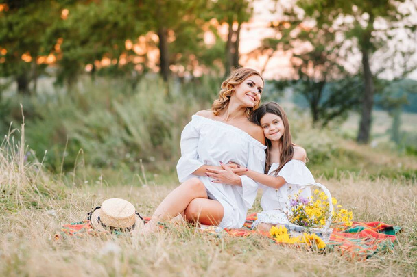 Stylish mother and handsome daughter having fun on the nature. Happy family concept. Beauty nature scene with family outdoor lifestyle. family resting together. Happiness in family life. Mothers day - Foto, immagini