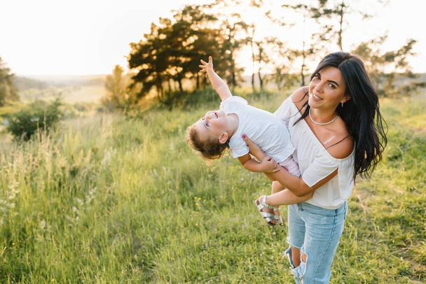 Stylish mother and handsome daughter having fun on the nature. Happy family concept. Beauty nature scene with family outdoor lifestyle. family resting together. Happiness in family life. Mothers day - Photo, Image
