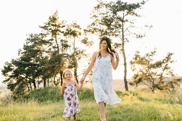 母と娘は公園で楽しんでいます。家庭生活の中での幸福と調和。家族のアウトドアライフスタイルと美容自然シーン. - 写真・画像
