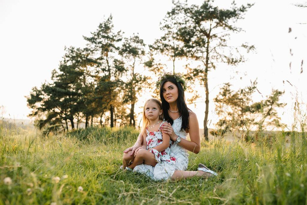 Anne ve kızı parkta eğleniyor. Aile yaşamında mutluluk ve uyum. Aile hayatı olan güzel doğa manzarası.. - Fotoğraf, Görsel