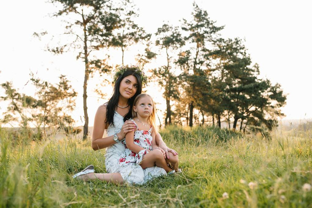 Stylish mother and handsome daughter having fun on the nature. Happy family concept. Beauty nature scene with family outdoor lifestyle. family resting together. Happiness in family life. Mothers day - Foto, Imagen