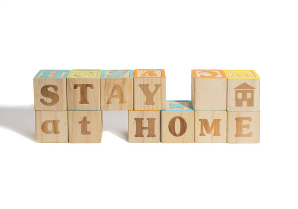 Resta a casa. messaggio scritto in blocchi di legno per incoraggiare le persone durante la quarantena con sfondo bianco
 - Foto, immagini