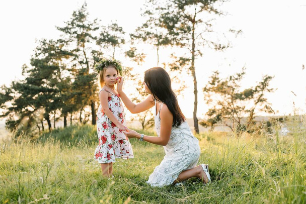 Äiti ja tytär pitävät hauskaa puistossa. Onnellisuus ja harmonia perhe-elämässä. Kauneus luonto kohtaus perheen ulkona elämäntapa
. - Valokuva, kuva
