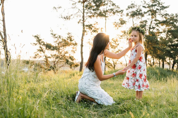 Mother and daughter having fun in the park. Happiness and harmony in family life. Beauty nature scene with family outdoor lifestyle. - Zdjęcie, obraz