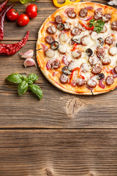 Pizza na staré dřevěné desce - Fotografie, Obrázek