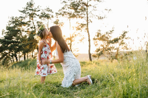 Stylish mother and handsome daughter having fun on the nature. Happy family concept. Beauty nature scene with family outdoor lifestyle. family resting together. Happiness in family life. Mothers day - Photo, image