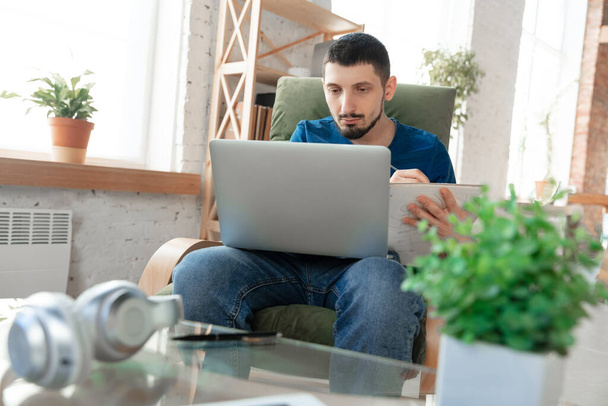 Young focused man studying at home during online courses or free information by hisself - Photo, Image