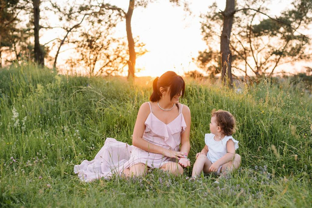 Anne ve kızı parkta eğleniyor. Aile yaşamında mutluluk ve uyum. Aile hayatı olan güzel doğa manzarası.. - Fotoğraf, Görsel