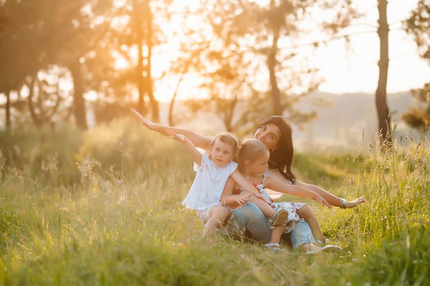 Matka i dwie córki bawią się w parku. Szczęście i harmonia w życiu rodzinnym. piękno natura scena z rodzina odkryty styl życia. - Zdjęcie, obraz