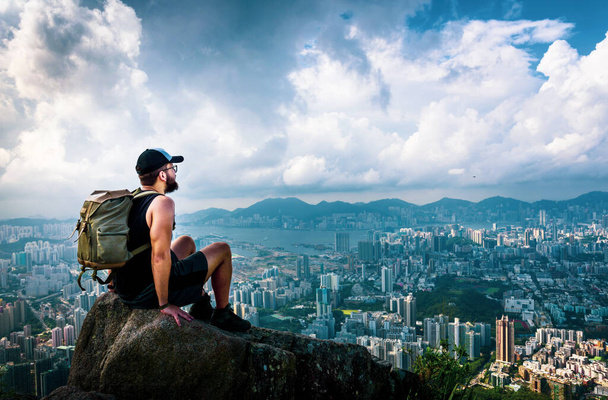 Aslan kayasından Hong Kong manzarasının tadını çıkaran bir adam. - Fotoğraf, Görsel