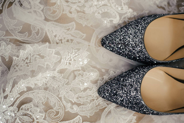 beautiful stylish gray high-heeled shoes from a famous brand are standing in a white laced veil - Φωτογραφία, εικόνα