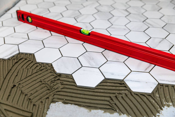 tegels - leggen van marmeren textuur zeshoekige tegels op de vloer - Foto, afbeelding