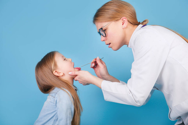 Doctor pediatrician examining cute child with throat sick - Фото, зображення
