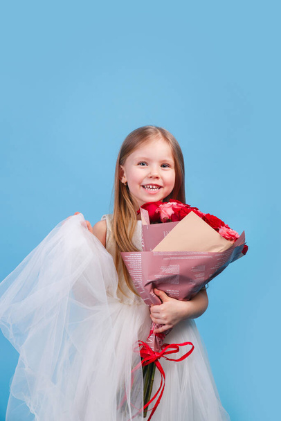 Little girl giving flowers to her mom on mother's day on blue background - Photo, Image