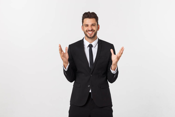 Retrato de un guapo modelo masculino expresando sorpresa y alegría levantando las manos, aislado sobre fondo blanco
. - Foto, Imagen