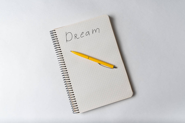 Вид сверху блокнота с надписью Dream и ручкой. Мотивационная записка. Список желаний
. - Фото, изображение