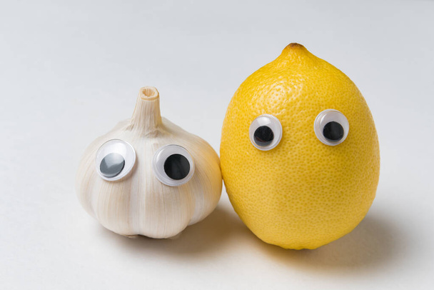 レモンとニンニクの良い目と面白い顔。健康食品の概念. - 写真・画像