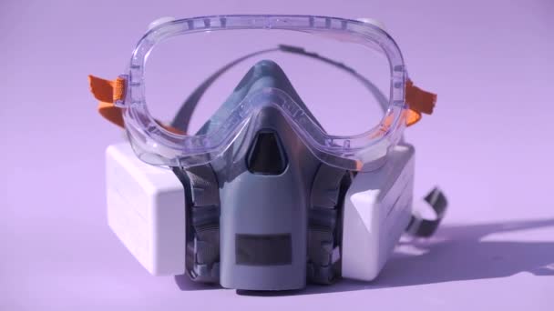 Pół maski respirator z okularami na różowym tle. - Materiał filmowy, wideo