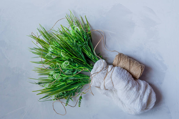 штучна зелена трава з коричневою ниткою на сірому фоні
 - Фото, зображення