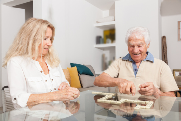 Happy senior couple playing game Dominoes - Photo, Image