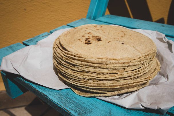 Stack of Corn Tortillas on Paper and Blue Wood - Photo, Image
