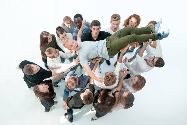 top view.happy team of young people tossing up their leader. - Zdjęcie, obraz