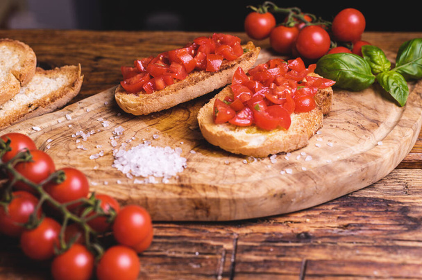 Italian bruschetta, toasted bred with fresh tomato and basil on woody vintage table - Φωτογραφία, εικόνα