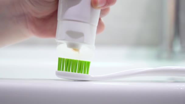 Lavarsi i denti ai bambini in bagno. Il bambino mette il dentifricio su una spazzola - Filmati, video