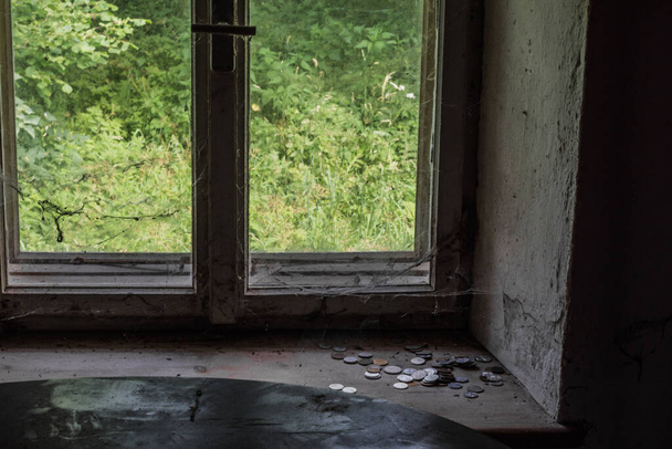 Terk edilmiş bir evin pencere eşiğindeki eski paralar. - Fotoğraf, Görsel