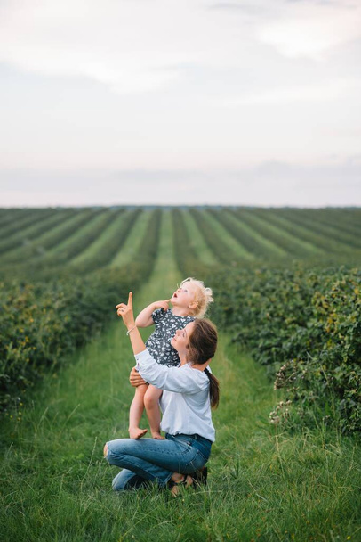 Stilish mother and daughter having fun on the nature. Happy family concept. Beauty nature scene with family outdoor lifestyle. Happy family resting together. Happiness in family life. Mothers day. - Photo, Image