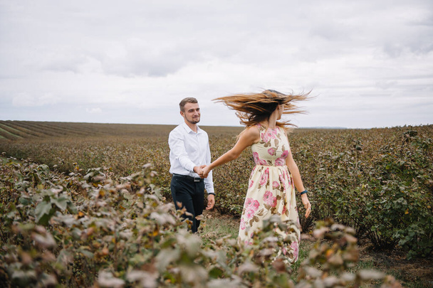 A girl and a guy are walking in the nature. Portrait of a couple, a love story.Happy smiling, loveing couple together outstretched at beautiful nature. Lovestory - Fotó, kép