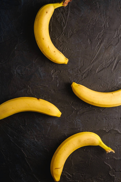 Banana fruits on dark textured background, top view - Photo, Image