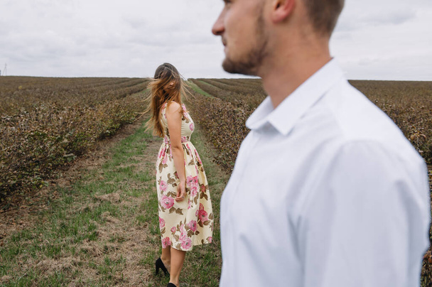 A girl and a guy are walking in the nature. Portrait of a couple, a love story.Happy smiling, loveing couple together outstretched at beautiful nature. Lovestory - Photo, Image
