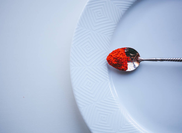 red pepper on a spoon on a white background - Zdjęcie, obraz