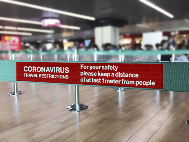 Barriera a nastro verde all'interno di un aeroporto con l'avvertimento della distanza di sicurezza dovuta alla diffusione del pericoloso Coronavirus
 - Foto, immagini