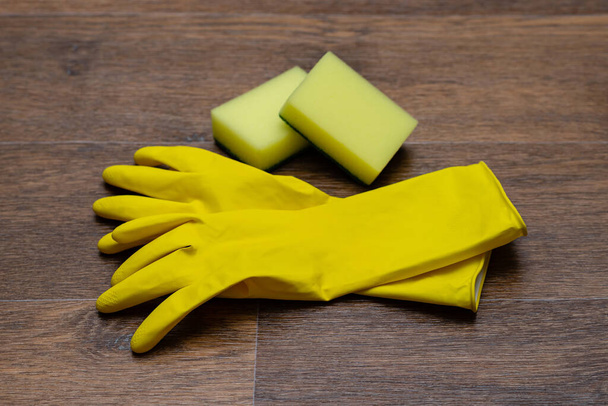 Sarı lastik eldivenler ve tahta arka planda havlular. - Fotoğraf, Görsel