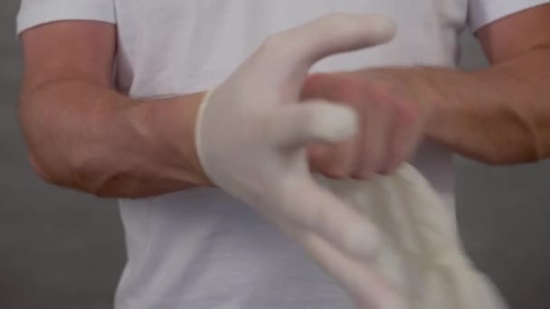 a man puts on protective medical gloves to protect against coronavirus - Záběry, video