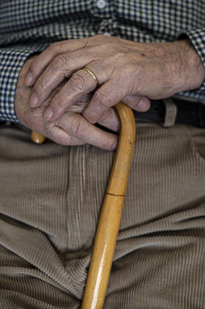 Anciano descansando en una mecedora con un bastón
 - Foto, imagen