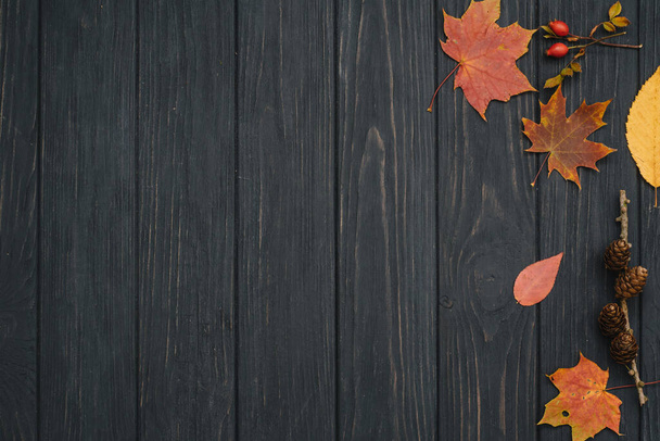 Background texture with old wooden table and yellow autumnal leaves. Autumn maple leaves on wooden background with copy space. Top view - Photo, Image