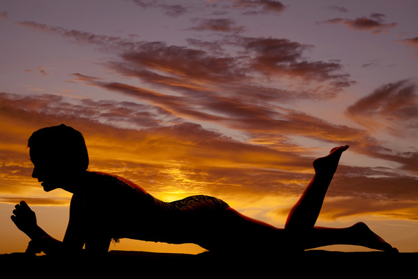 mulher ao pôr-do-sol de joelhos e cotovelos virados para baixo
 - Foto, Imagem
