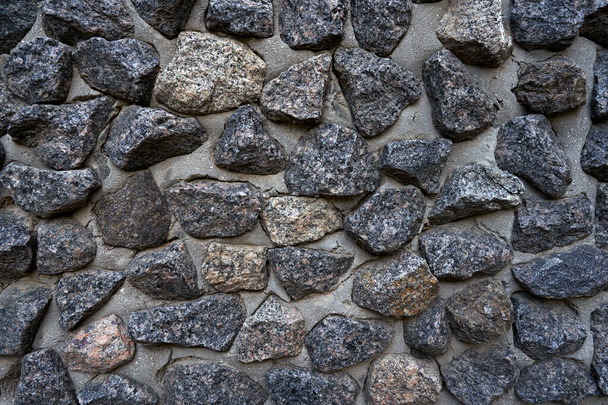 Nahaufnahme des alten schmutzigen Zauns aus Naturstein und Zement   - Foto, Bild