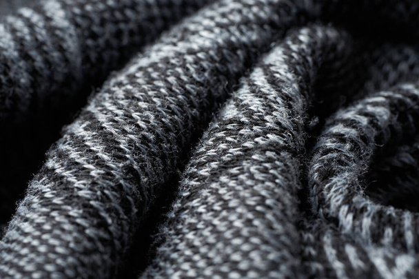 Nahaufnahme graue Textur aus Wollstrick. Muster aus grau zerknülltem Stoff. Hochwertige selektive Fokus-Makrofotografie. - Foto, Bild