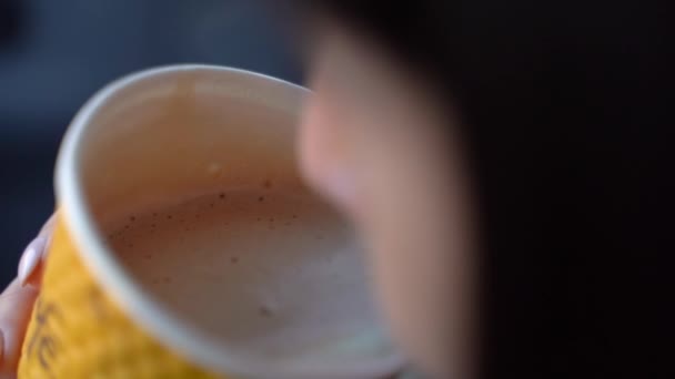 Girl drinks coffee in a car. Slow motion - Felvétel, videó