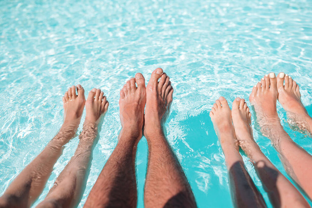 Gros plan de quatre personnes jambes au bord de la piscine
 - Photo, image