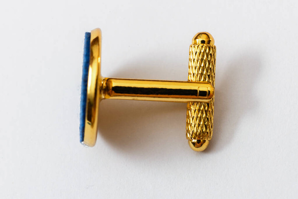 golden metal cufflink with a blue felt on a white background - Photo, Image
